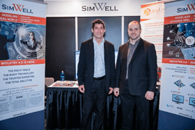 Founder & CEO Alexandre Ouellet and CTO, Andre Jacqués standing in front of the SimWell booth 