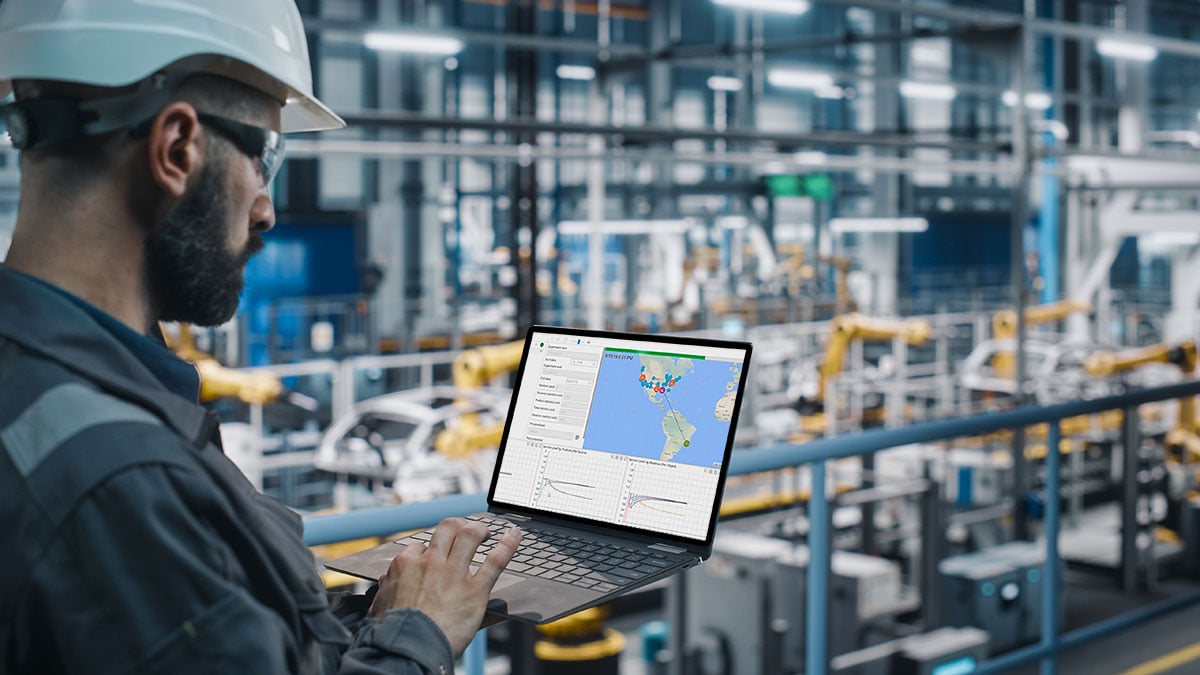 Ingeniero de fábrica de automóviles en uniforme de trabajo usando computadora portátil con pantalla de computadora portátil