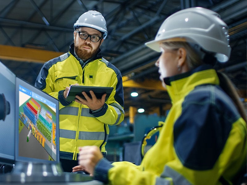 À l'intérieur de l'usine de l'industrie lourde Une ingénieure industrielle travaille sur un ordinateur personnel