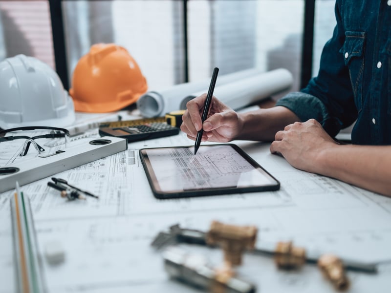 Ingeniero que planea en una tableta en su mesa de trabajo